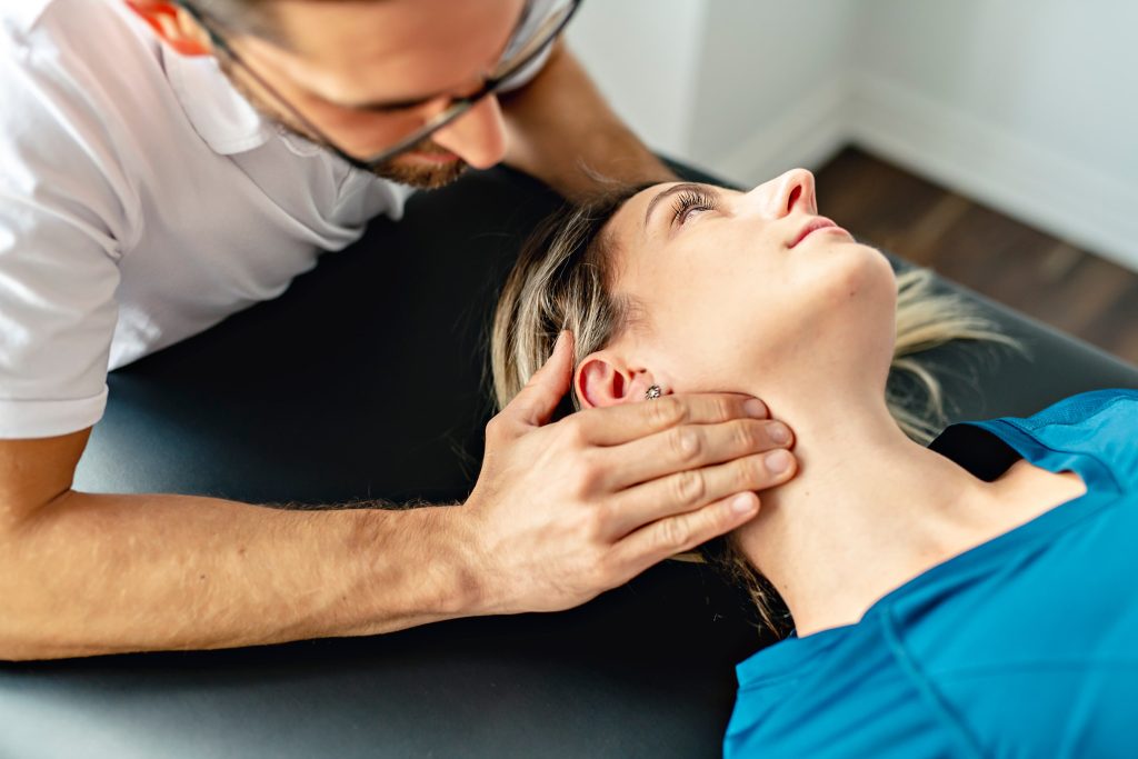 chiropractor aligning a woman's neck